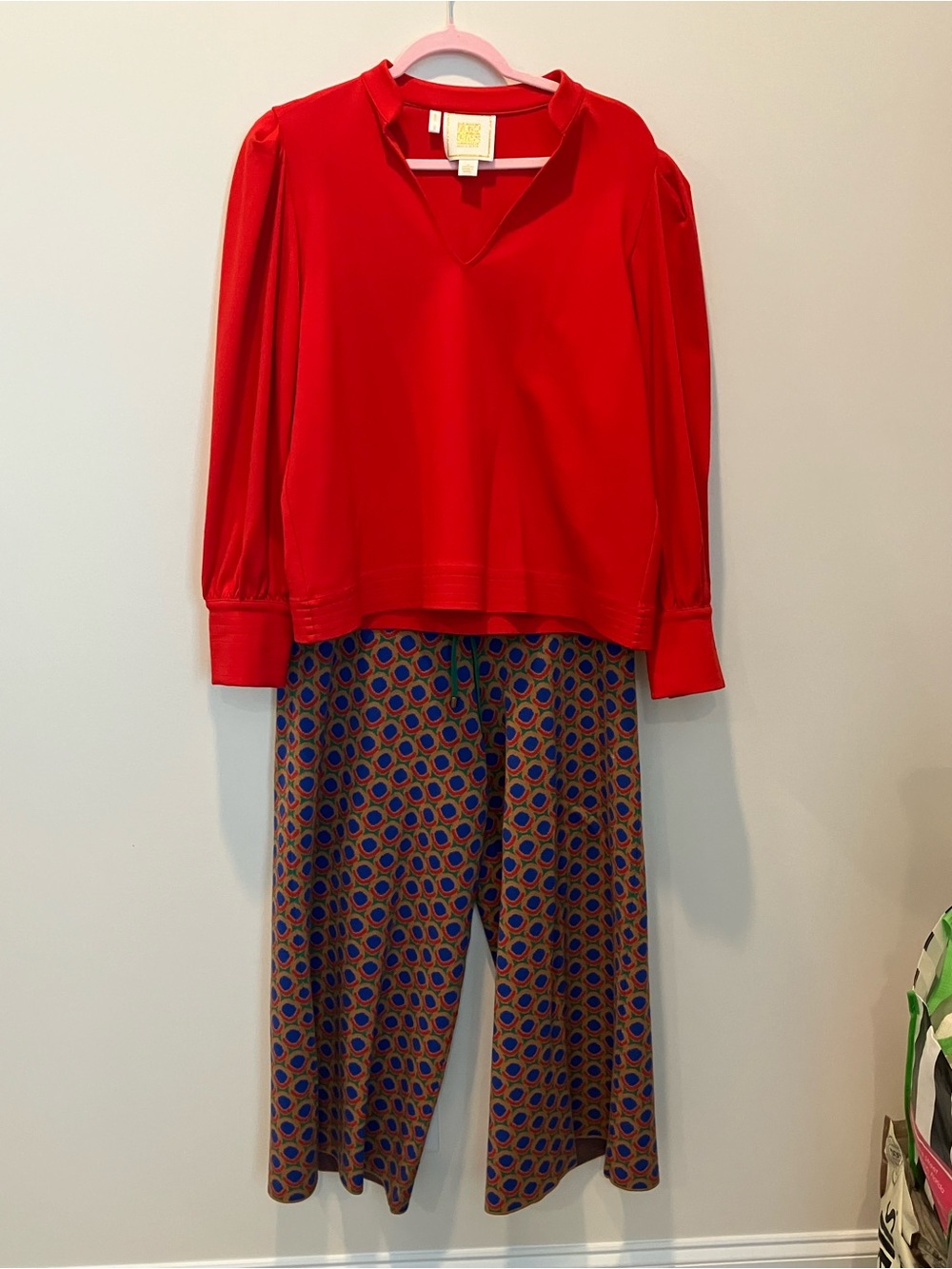 Emily McCarthy Women's Red Top and Patterned Pants Outfit